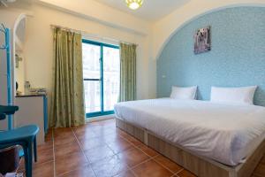 um quarto com uma cama com uma parede azul em Rainbow B&B em Dahan