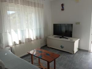 ein Wohnzimmer mit einem TV und einem Tisch in der Unterkunft KATY&MLADEN in Baška