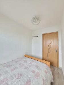 Schlafzimmer mit einem Bett und einer Holztür in der Unterkunft Giedres Kalnieciu apartments in Kaunas