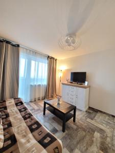 a room with two beds and a table and a tv at Giedres Kalnieciu apartments in Kaunas