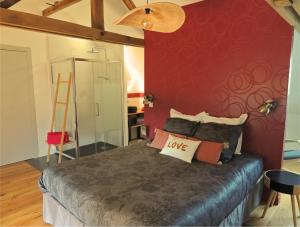 sypialnia z łóżkiem i czerwoną ścianą w obiekcie Céshap - Chambres d'hôtes w mieście Taden
