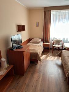a hotel room with two beds and a flat screen tv at Chata Rybaka in Ustronie Morskie