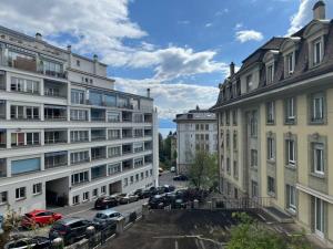 vista de los edificios de una ciudad con coches aparcados en Studio ensoleillé avec balcon en Lausana