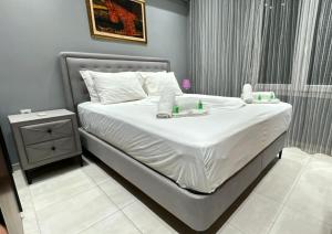 1 dormitorio con 1 cama con sábanas blancas y mesa en Moza House en Kavala