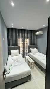 1 dormitorio con 2 camas y ventana en Moza House, en Kavala