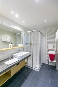 un baño con lavabo y ducha en Hotel Schönblick, en Lochau
