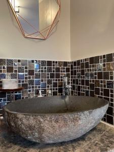 een groot stenen bad in een badkamer met een spiegel bij Orchard Retreat Staycation in Boston