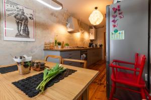 a kitchen with a wooden table and a red chair at Reszel Art House in Reszel