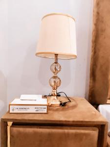 a lamp sitting on top of a table with a book at SR Apartments Islamabad in Islamabad