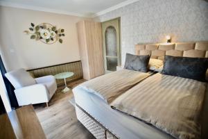 um quarto com uma cama grande e uma cadeira em Crystal Apartman em Mórahalom