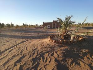 a house in the middle of a dirt road at Volunteer in desert in Mhamid