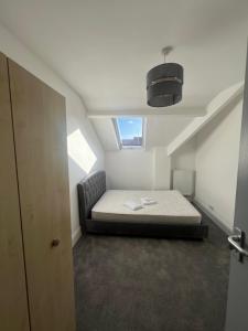 a small bedroom with a bed in a attic at Bryn Road House in Sketty