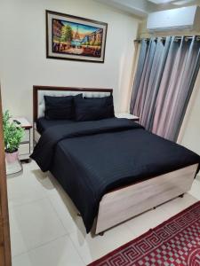 - une chambre avec un grand lit dans l'établissement SR Apartments Islamabad, à Islamabad