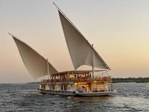a boat with three sails on the water at Dahabiya Nile Sailing - Mondays 4 Nights from Luxor - Fridays 3 Nights from Aswan in Luxor