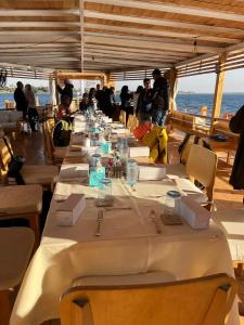 a long table on a boat with people standing around it at Dahabiya Nile Sailing - Mondays 4 Nights from Luxor - Fridays 3 Nights from Aswan in Luxor