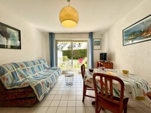 uma sala de estar com um sofá e uma mesa em Appartement Carnac, 2 pièces, 4 personnes - FR-1-377-15 em Carnac