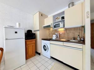 uma cozinha com um frigorífico branco e uma máquina de lavar louça em Appartement Carnac, 2 pièces, 4 personnes - FR-1-377-15 em Carnac