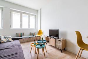 ein Wohnzimmer mit einem Sofa und einem TV in der Unterkunft Studio Au coeur de la baie in Berck-sur-Mer