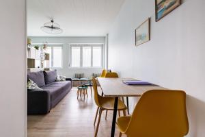 ein Wohnzimmer mit einem Tisch und gelben Stühlen in der Unterkunft Studio Au coeur de la baie in Berck-sur-Mer