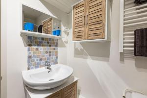 une salle de bains blanche avec un lavabo et un miroir dans l'établissement Studio Au coeur de la baie, à Berck-sur-Mer 10 autres photos
