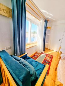 een slaapkamer met een blauwe bank en een raam bij Dahabiya Nile Sailing - Mondays 4 Nights from Luxor - Fridays 3 Nights from Aswan in Luxor