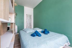 une chambre avec un lit avec des oreillers bleus dessus dans l'établissement Studio Au coeur de la baie, à Berck-sur-Mer