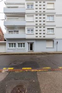 un grand bâtiment blanc avec une rue en face dans l'établissement Studio Au coeur de la baie, à Berck-sur-Mer