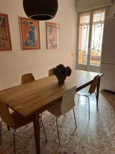 a dining room table with chairs and a vase on it at Moonlight Centro Bologna in Bologna