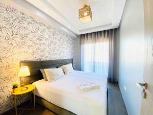 a bedroom with a large white bed and a yellow table at Sunny OASIS 2 Bedrooms - By AppartAli in Casablanca