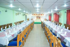 un salón de banquetes con mesas y sillas con manteles blancos en Rainbow Guest House en Sylhet