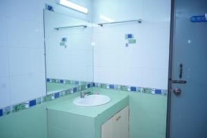 W łazience znajduje się umywalka i lustro. w obiekcie Rainbow Guest House w mieście Srihotto