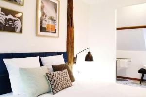 a bedroom with white walls and a bed with pillows at Paradis nature dans Le PERCHE - Vue, Confort, Pêche, Étang, Salle de Sport, à 5min Ville & Gare in Belhomert-Guéhouville
