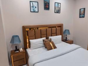ein Schlafzimmer mit einem Bett mit zwei Lampen an Nachttischen in der Unterkunft Morbex Guest House Islamabad in Islamabad