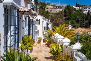 une rue en positano avec des maisons et des plantes blanches dans l'établissement Nice cozy townhouse with views, à Mijas