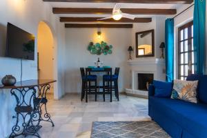 - un salon avec un canapé bleu et une table dans l'établissement Nice cozy townhouse with views, à Mijas