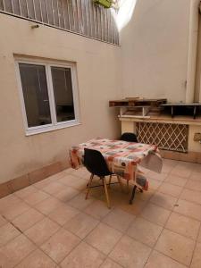 eine Küche mit einem Tisch, 2 Stühlen, einem Tisch und einem Tisch in der Unterkunft proche maison carrée in Nîmes