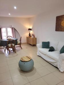 ein Wohnzimmer mit einem weißen Sofa und einem Tisch in der Unterkunft proche maison carrée in Nîmes