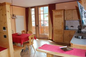 a kitchen with a table with a red table cloth at Appartamento Joemy in Livigno