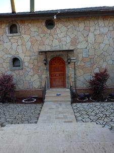 a stone building with a wooden door and stairs at Villa Atroa Gölevi in Orhangazi