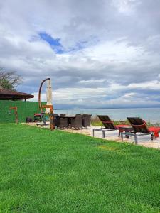 eine Gruppe Stühle und ein Tisch am Strand in der Unterkunft Villa Atroa Gölevi in Orhangazi