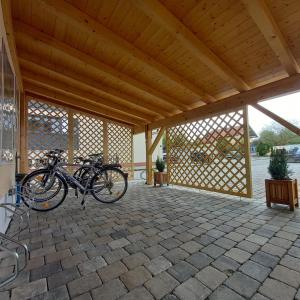 Duas bicicletas estacionadas num pátio com tecto de madeira em Haus Tobias em Bad Füssing