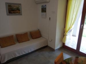a couch in a room with a window and a table at KATY&MLADEN in Baška
