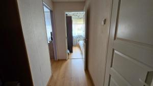 um quarto vazio com um corredor que leva a um quarto com uma porta em Smile Appartment em Tartu