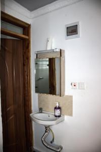 ein Badezimmer mit einem Waschbecken und einem Spiegel an der Wand in der Unterkunft One bedroom unit with wi-fi & parking in Nanyuki