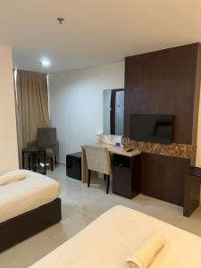 a hotel room with a bed and a desk and a television at Studio Exclusive (Kota Bharu City Point) in Kota Bharu