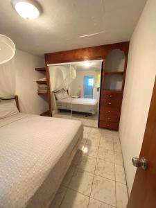 - une chambre avec un lit et un miroir dans l'établissement Coconut house Charlestown nevis, à Charlestown