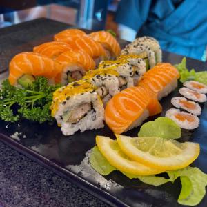 a plate with sushi and vegetables on a table at Hotel Neo Cologne Bonn Airport in Rösrath