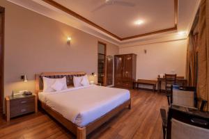 a bedroom with a bed and a desk and a chair at Nature View Resort !! A Four Star Lavish & Luxury Resort in Chail