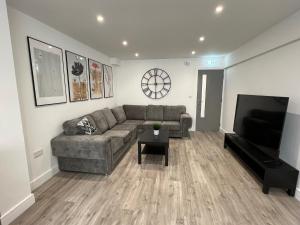 a living room with a couch and a flat screen tv at We House One - Birmingham in Birmingham