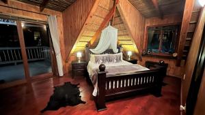 a bedroom with a bed in a room with wooden walls at Kruger Kumba - Mugwenzi in Marloth Park